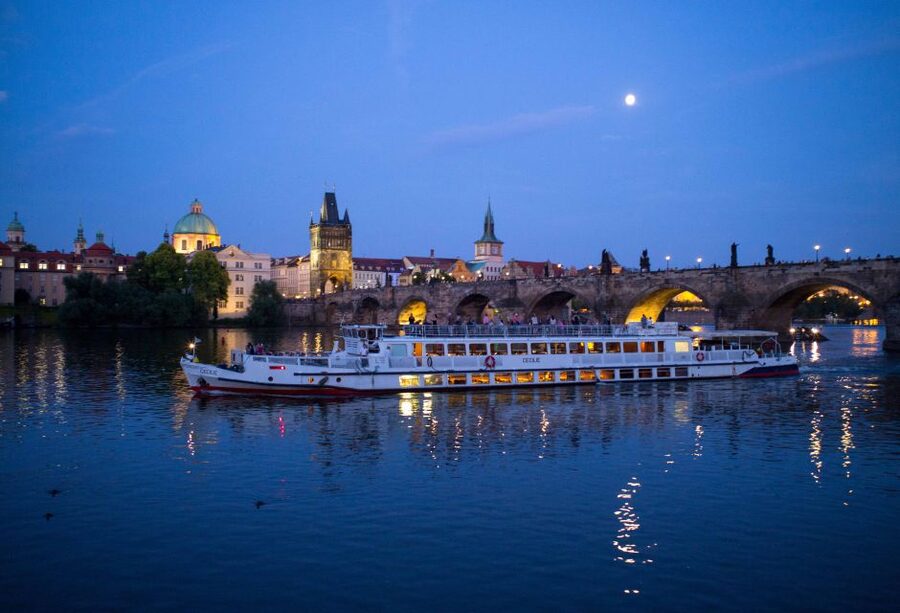 Prague: City Tour and Dinner Cruise with Hotel Pickup - Boarding the luxury boat: welcome drink, open decks, and floodlit Prague Castle